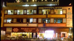 Et hotel med flere etager, skilte med 'Sunder Plaza' og 'Hotel Midtown Grand'.