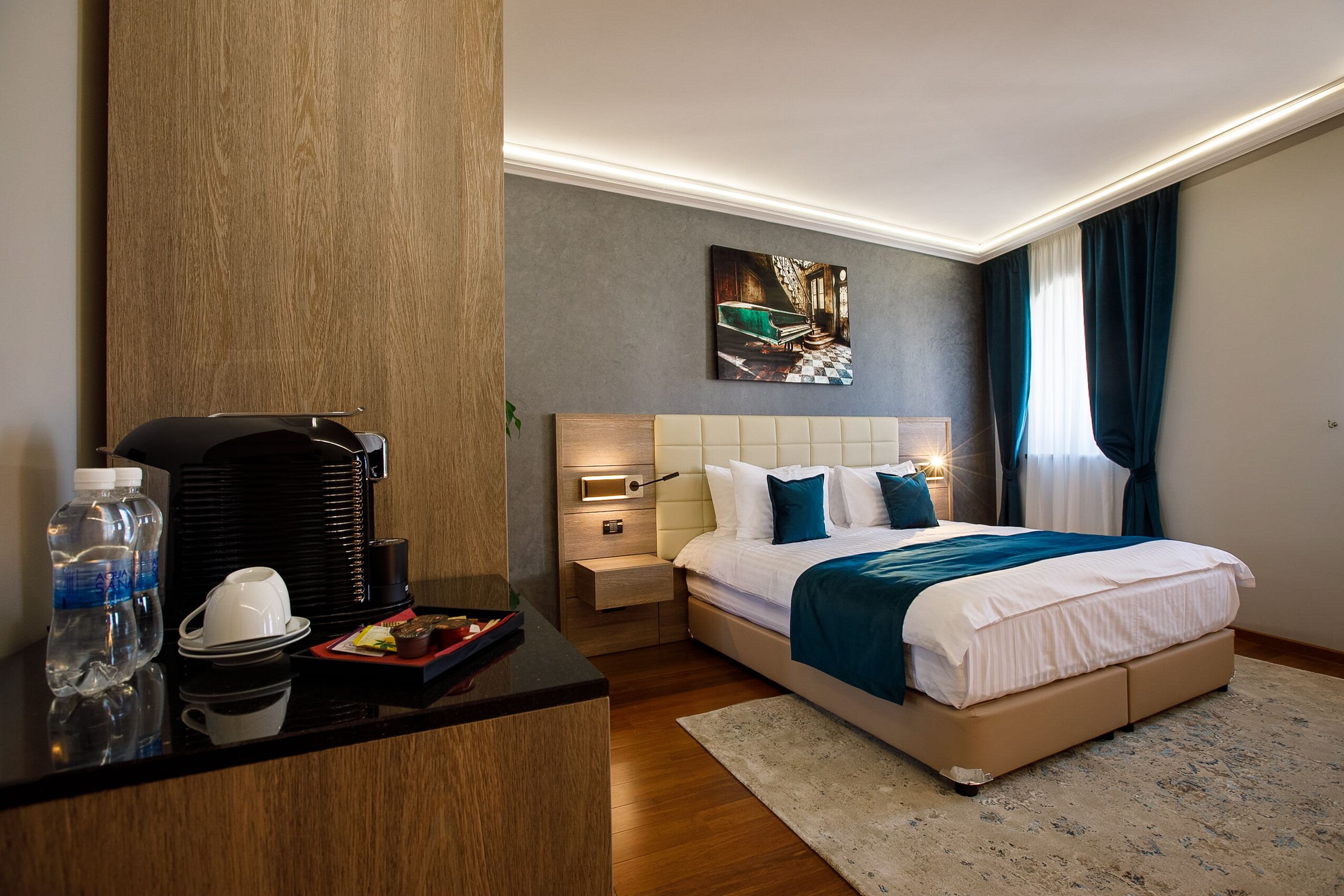 Une chambre d’hôtel avec un lit, une table de chevet et un tableau au mur.