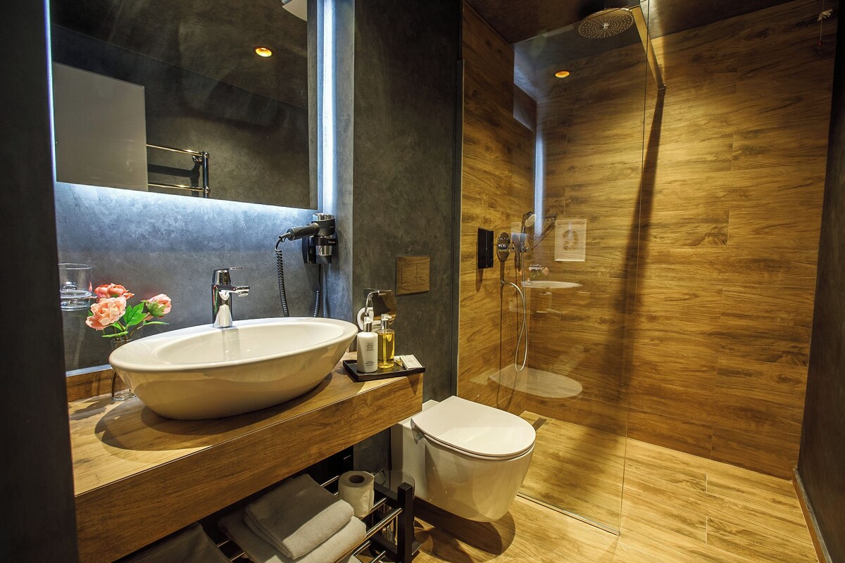 A modern bathroom with a large sink, toilet, and shower.