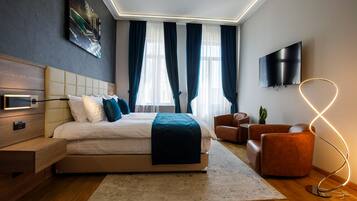 Quarto moderno com cama, mesa de cabeceira, televisão e luminária diferenciada.