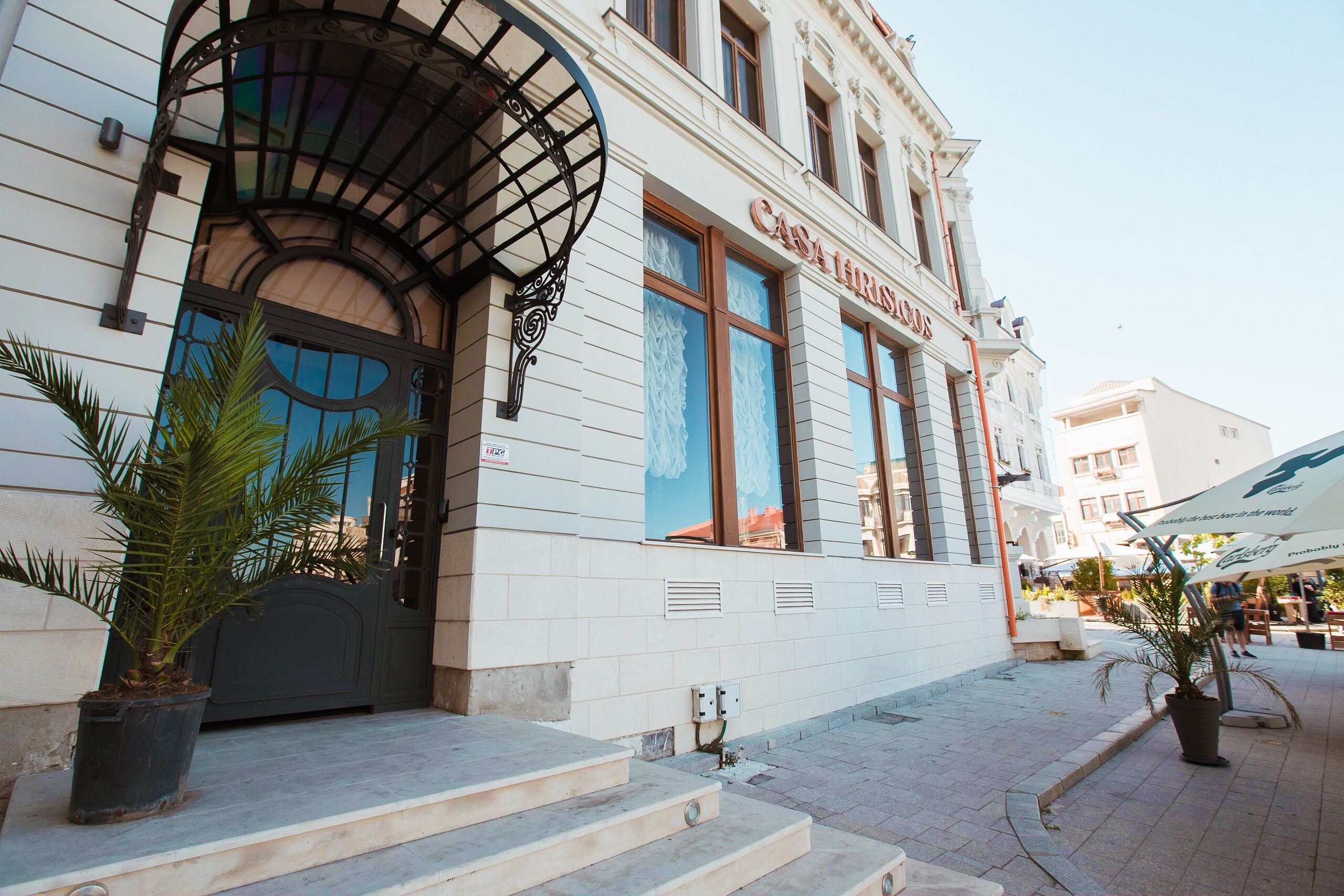 A building with a grand entrance, steps leading up to the door, and a sign that reads "Casa Famosa."
