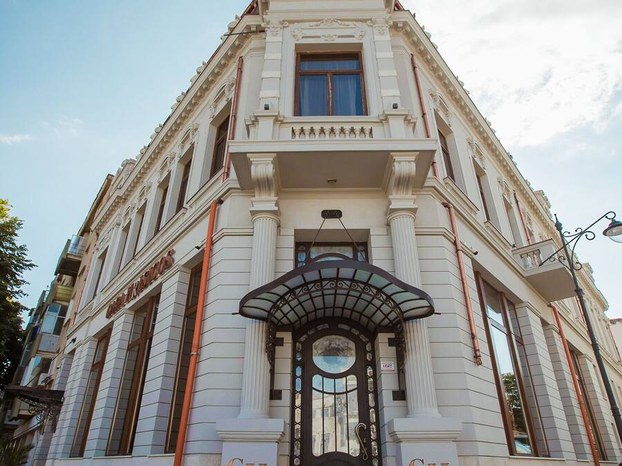 A historic building with a grand entrance, large steps, and a prominent 'CH' sign.