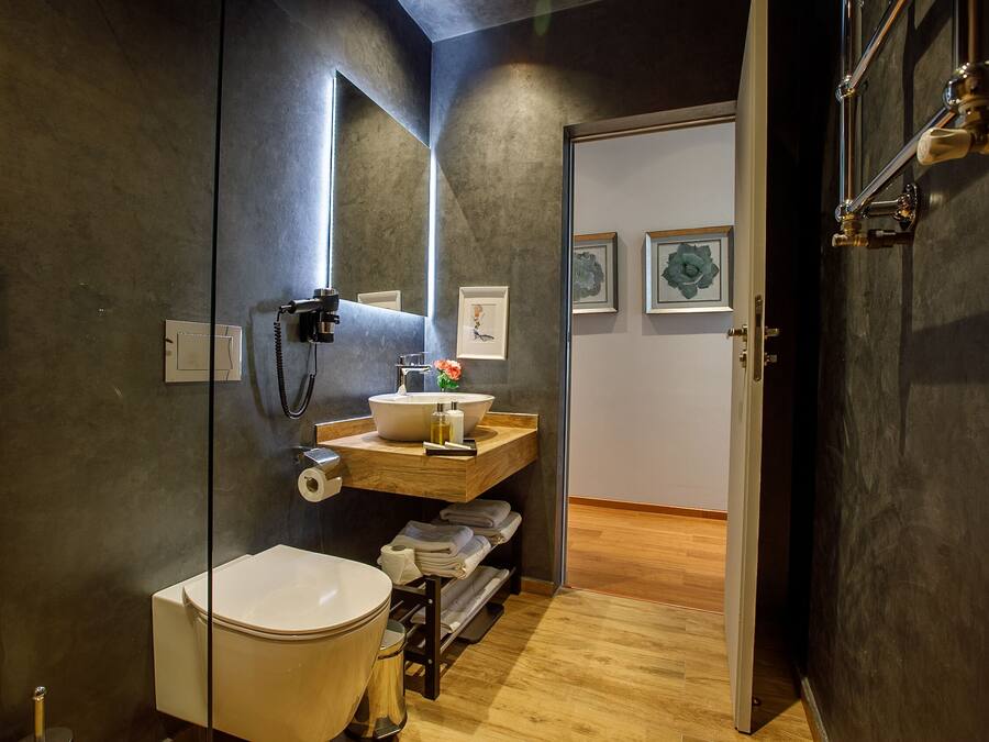 A modern bathroom with a toilet, sink, and mirror.