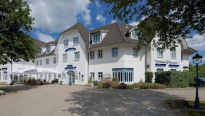 A large hotel with multiple dining areas and a well-maintained garden. - Hotel Wikingerhof (Kropp)