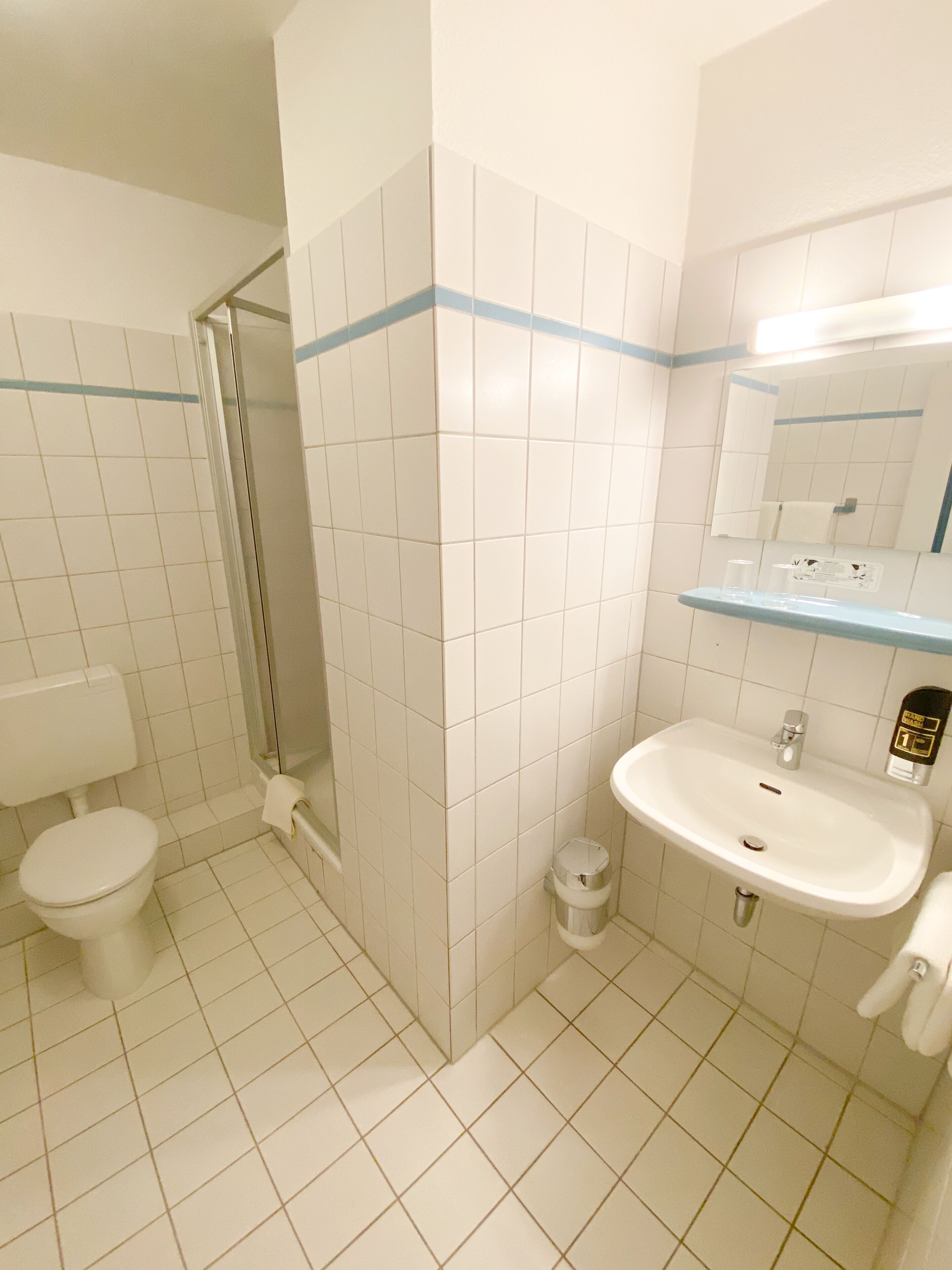 A bathroom with a toilet, sink, and shower.