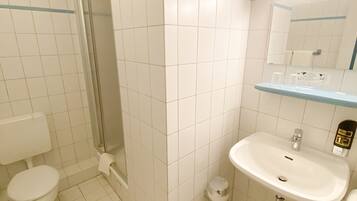 A bathroom with a toilet, sink, and shower.