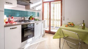 Une cuisine moderne équipée d’une cuisinière à gaz, d’un four et d’un coin repas avec une table mise pour deux personnes.