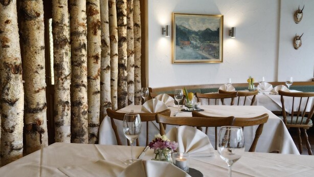 A restaurant with birch tree decor, white tablecloths, and a painting on the wall. - Fuxxbau Fischerbach (Fischerbach)