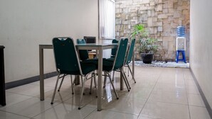 Comedor con mesa, sillas, una planta en maceta y dispensador de agua.