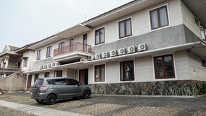 Un edificio de varios pisos con un balcón en el segundo nivel.