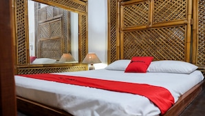 A bed with a red and white bedspread, a red pillow, and a wooden headboard with a lattice design. - RedDoorz Plus near Jalan Baru Bogor (Bogor)