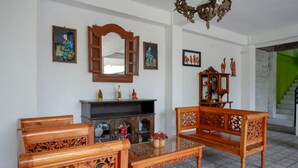 A traditional-style living room with a sofa, coffee table, and a fireplace. - RedDoorz @ Jalan Parangtritis (Sewon)