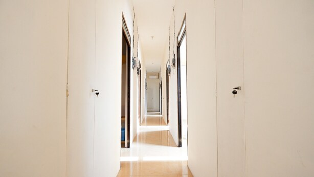A corridor with doors on both sides leading to rooms. - RedDoorz near Akademi Kepolisian Semarang (Semarang)