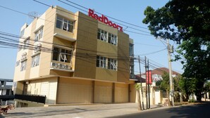 A multi-story building with a sign reading "RedDoorz" on the facade. - RedDoorz near Akademi Kepolisian Semarang (Semarang)