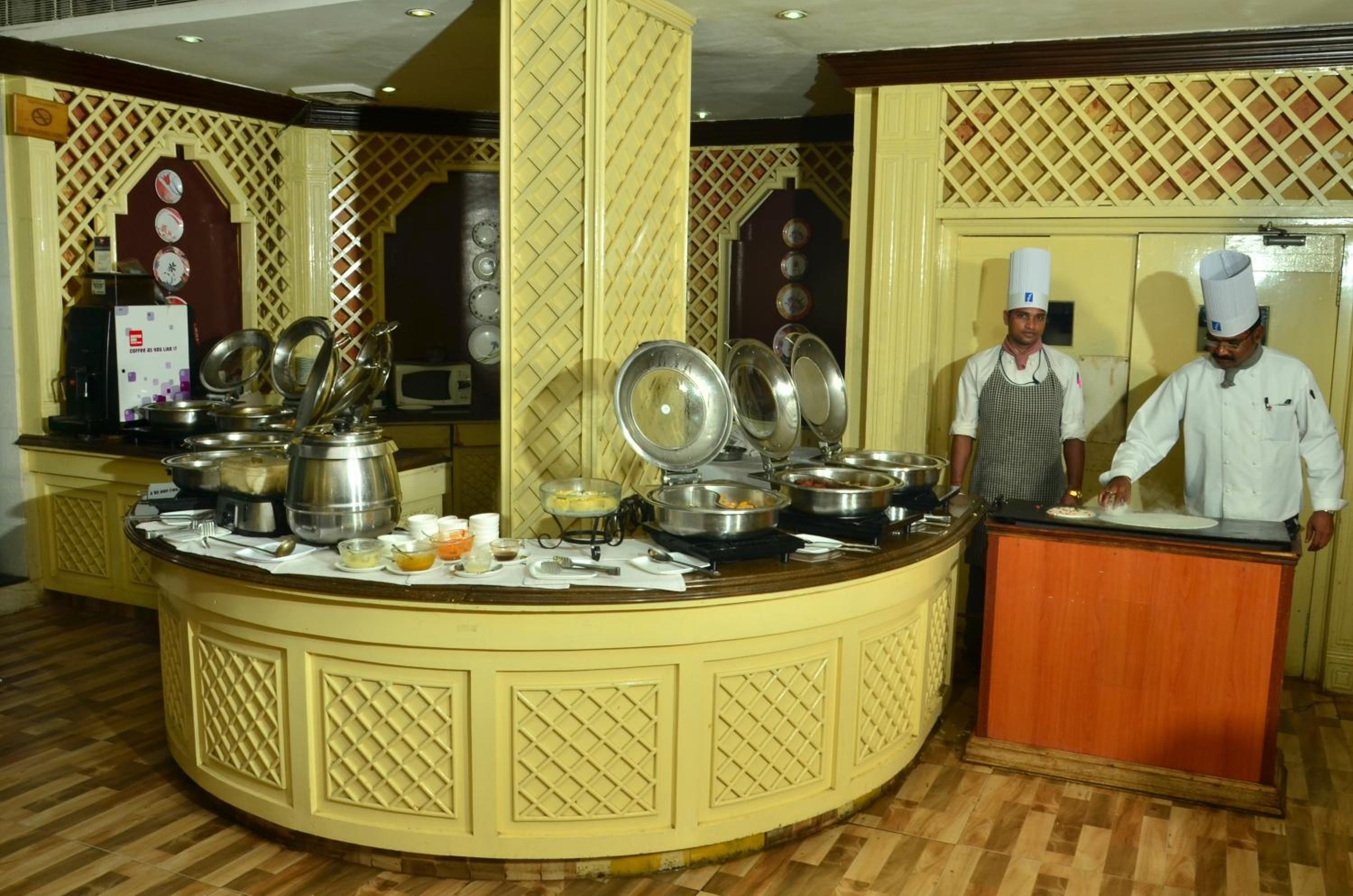 A buffet area with multiple serving stations, a coffee machine, and a microwave.