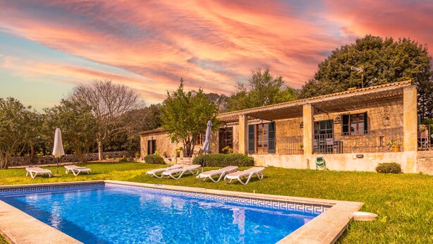 A swimming pool with lounge chairs and a covered patio area.