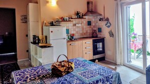 Une cuisine compacte équipée d’un réfrigérateur, d’une cuisinière et d’un coin repas avec une table et des chaises.