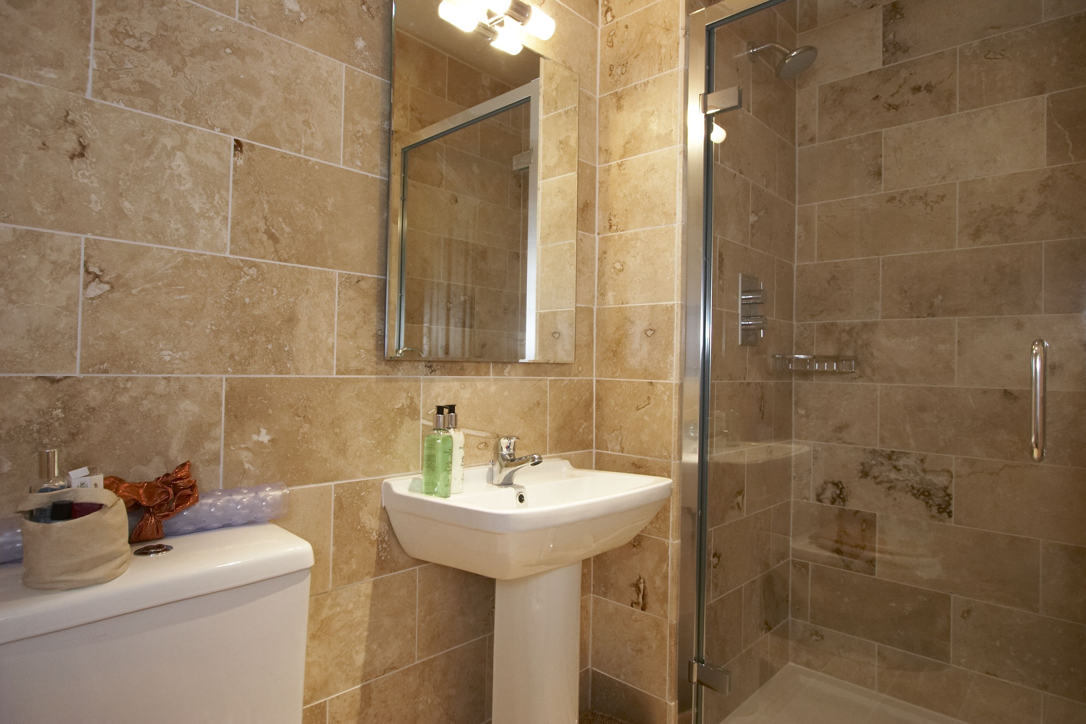 A bathroom with a sink, mirror, and shower.
