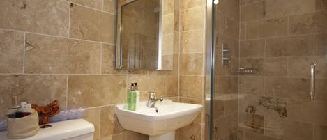 A bathroom with a sink, mirror, and shower.