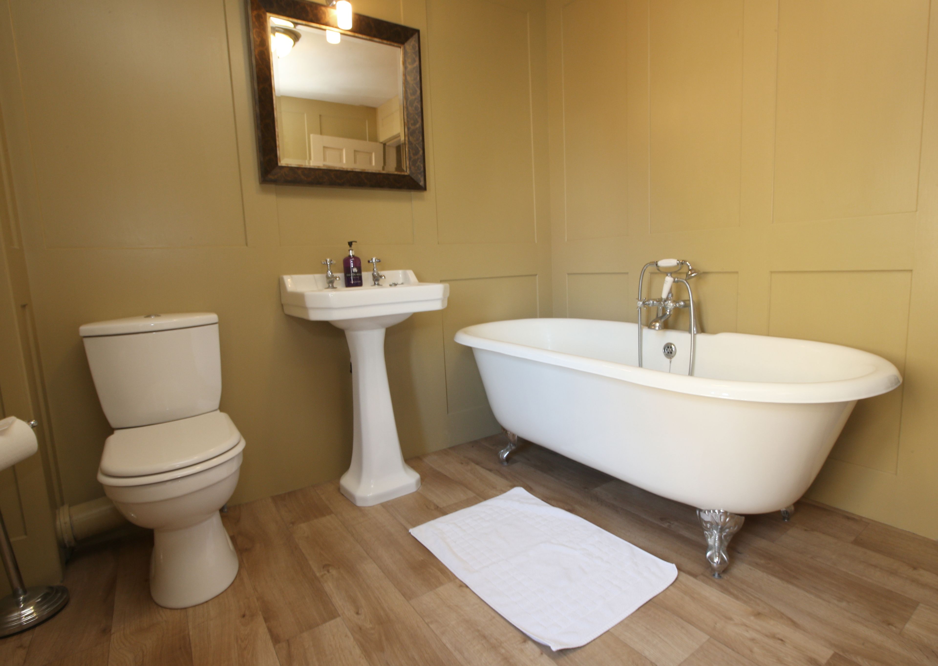A bathroom with a toilet, sink, and bathtub.