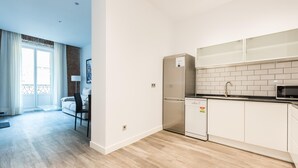 A modern kitchen with white cabinets, a stainless steel refrigerator, and a dishwasher. - PUERTA DEL SOL CITY CENTER WITH BALCONY (Madrid)