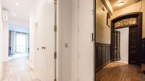 A hallway with a white door, a wooden floor, and a view to a balcony. - PUERTA DEL SOL CITY CENTER WITH BALCONY (Madrid)