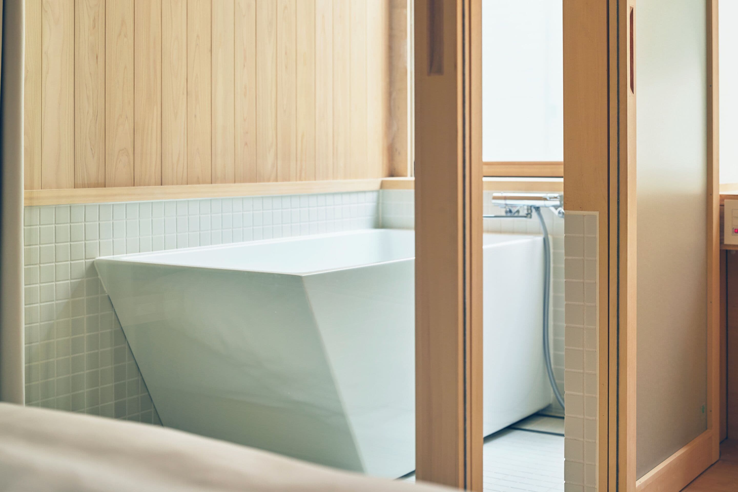A modern bathroom with a large bathtub, a shower, and a wooden vanity.