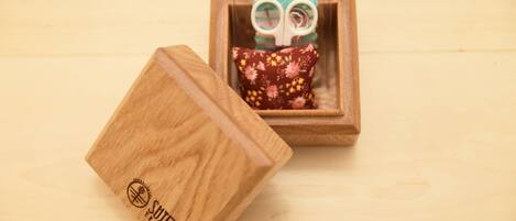 Una caja de madera con un cojín floral, colocada sobre una superficie de madera.