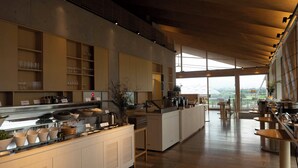 A modern kitchen with a long counter, various kitchen appliances, and a view of the outdoors.