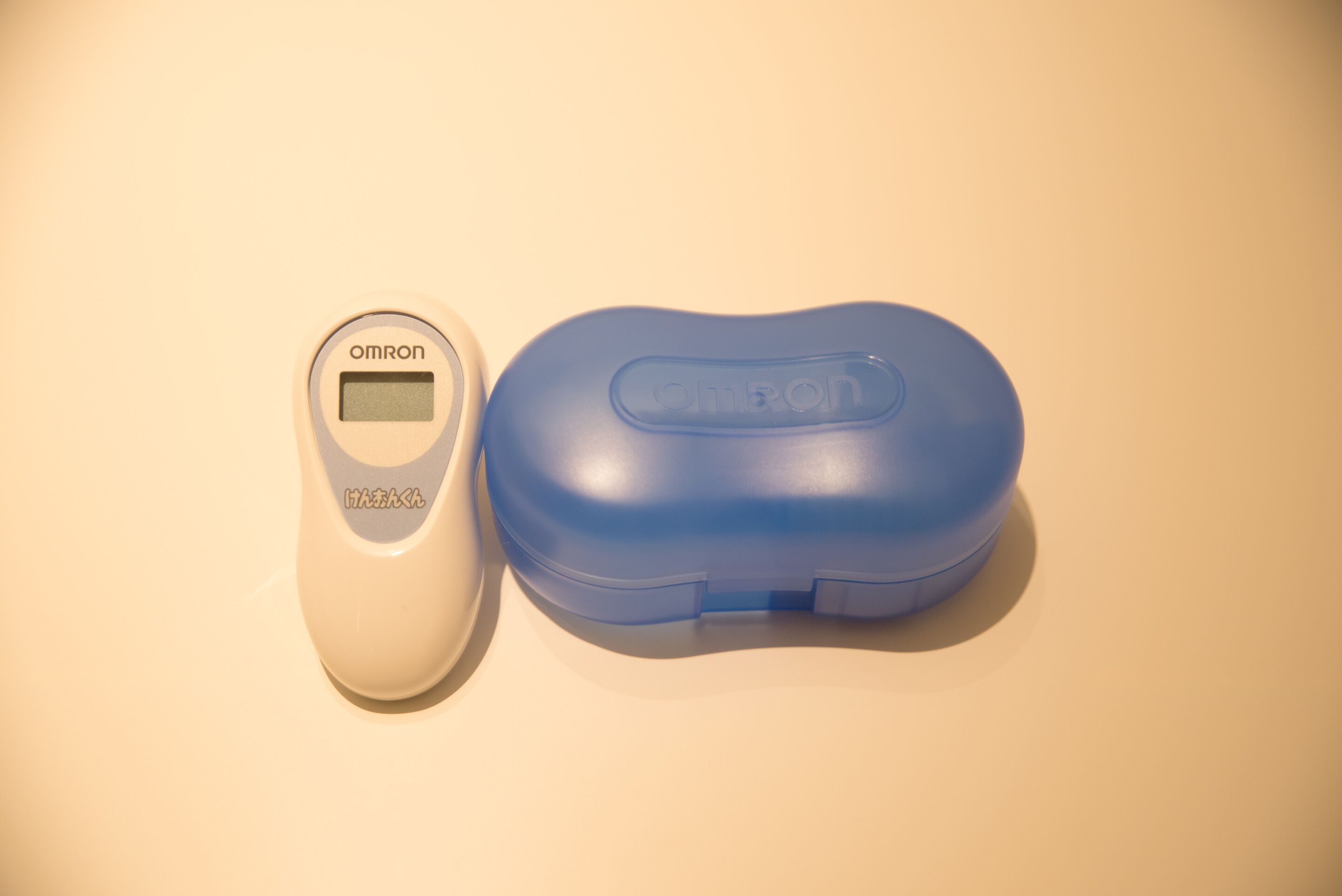 A digital scale and a blue container with the Omron logo.