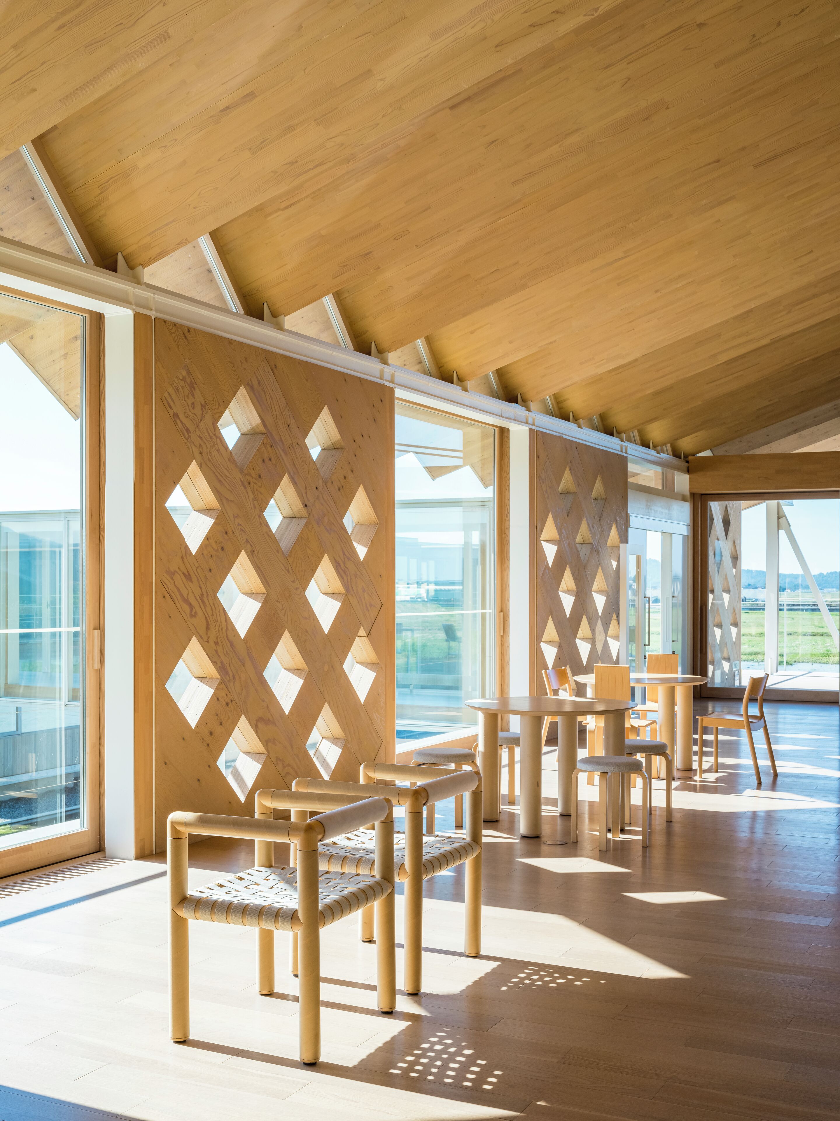 A spacious indoor area with wooden furniture and large windows.
