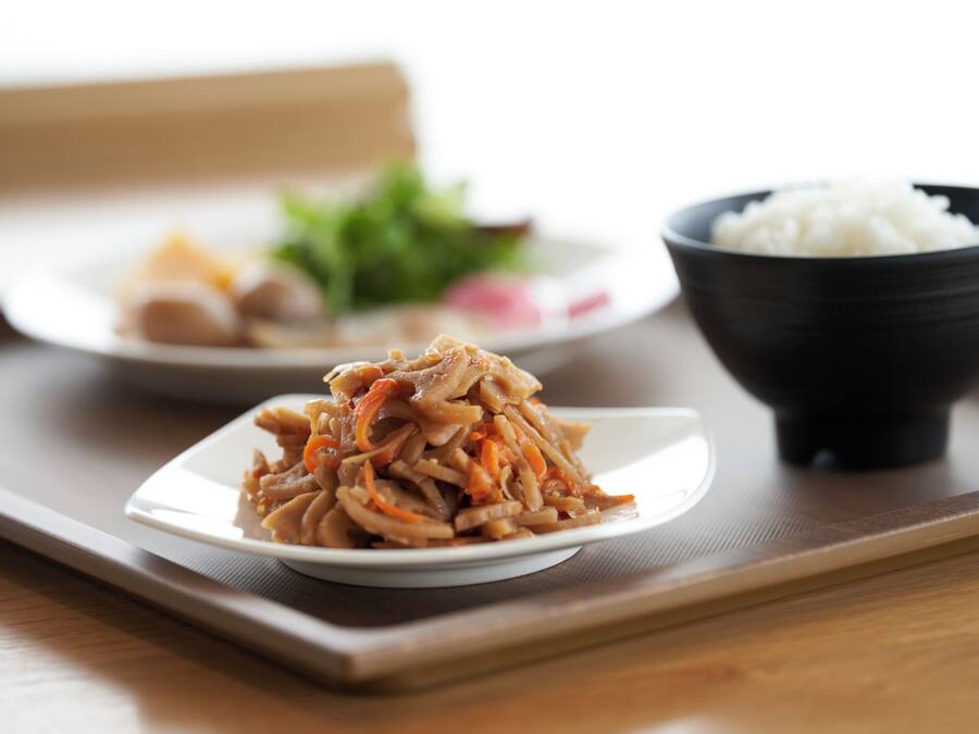 A tray with a plate of stir-fried vegetables and a bowl of white rice.