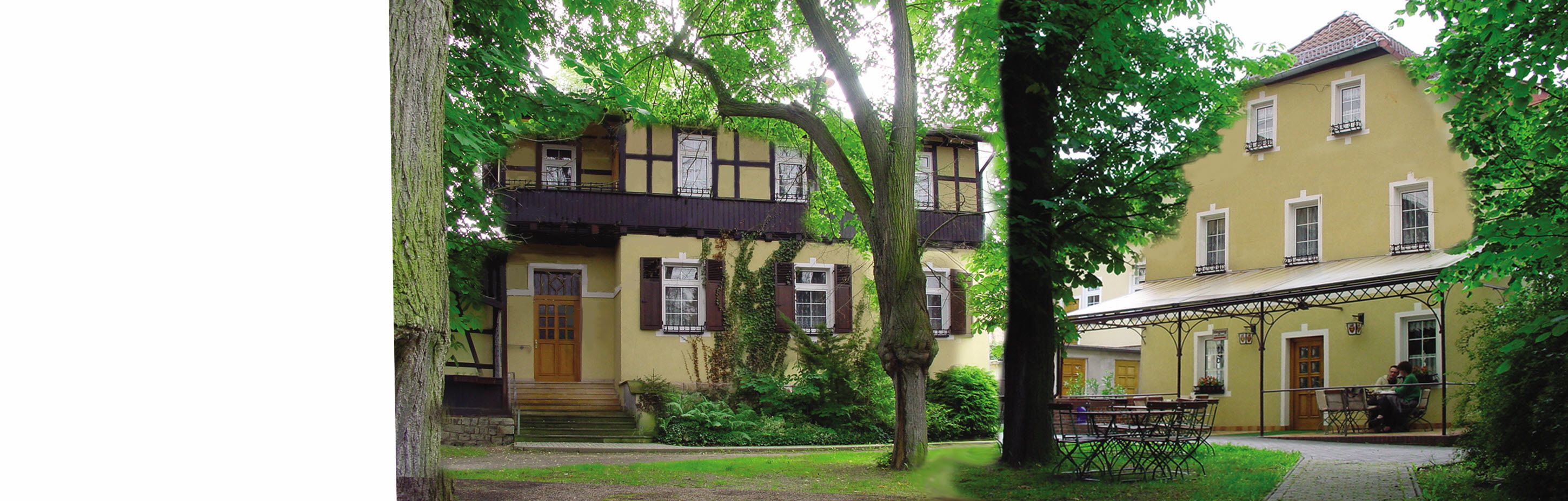A two-story building with a balcony and a covered outdoor seating area.