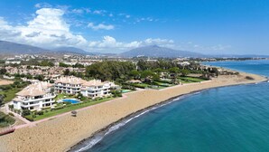 A coastal resort with beachfront villas, a swimming pool, and a view of the ocean and mountains. - 213 Lux-Serv Apart-Estepona, 2-B'room, All Year 28c, 20m Heated Pool. Sea Views (Estepona)