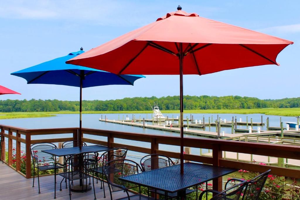 A deck with outdoor seating and a view of a lake and dock.