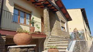 A building with a stone facade, a balcony with potted plants, and a sign with the number 7. - Chianti Best House - Comfort, relax & privacy in the center of Greve in Chianti (Greve in Chianti)