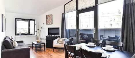 Departamento, 2 habitaciones | Área de sala de estar | Televisión de pantalla plana