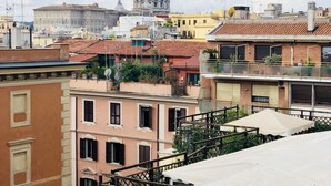 A cityscape with a prominent dome structure in the background, surrounded by residential buildings with varied architectural styles and colors. - Empire Suites (Rome)