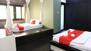 A hotel room with two beds, a large wardrobe, and a reception area with a phone and a brochure. - RedDoorz near Gia Dinh Church (Ho Chi Minh City)