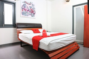 A bed with a red and white bedspread, a red pillow, and a red blanket. - RedDoorz near Gia Dinh Church (Ho Chi Minh City)