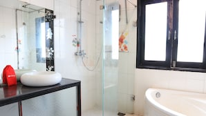 A bathroom with a glass-enclosed shower, a white sink, and a bathtub. - RedDoorz near Gia Dinh Church (Ho Chi Minh City)
