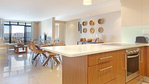 Une cuisine moderne dotée d’un grand îlot central, de meubles en bois et d’un four encastré.