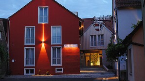 A red building with a sign for 'Hotel Roth' and 'Gerhard Rothing' visible. - RotHweinHotel (Wiesenbronn)