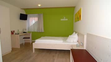 Une chambre avec un lit, un bureau et une chaise.