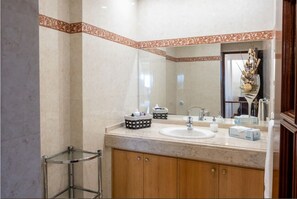 Een bad/douchecombinatie, een haardroger, een bidet, handdoeken