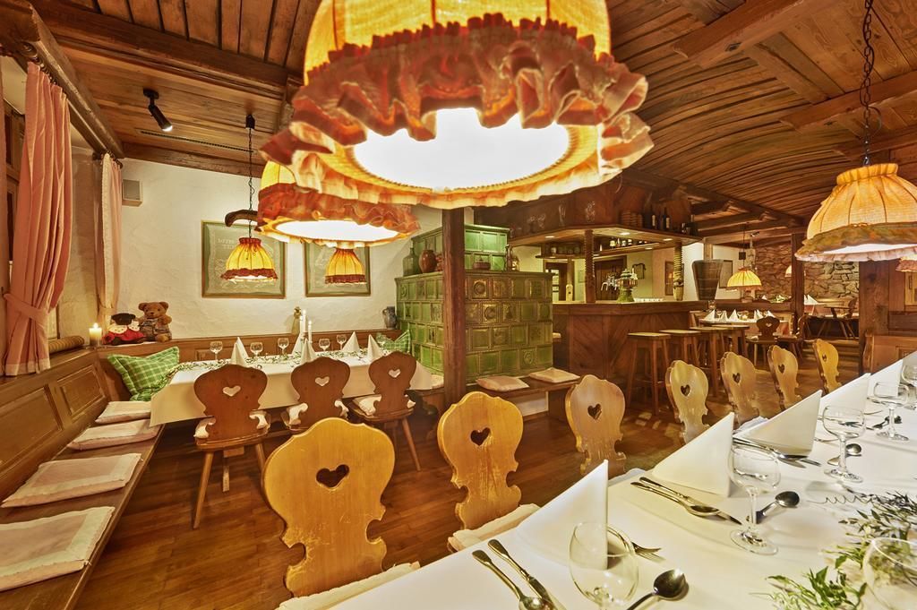 Ein Restaurant mit Holztischen, hängenden Lampen und einer Bar.