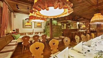 Ein Restaurant mit Holztischen, hängenden Lampen und einer Bar.