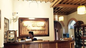 Un mostrador de recepción con un cartel que dice 'Mr. Charles Guest House'.