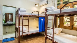 Habitación con literas y baño, que incluye un lavabo y espejo.
