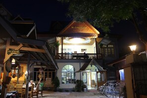 Un edificio de dos pisos con un letrero que dice 'Mr. Charles Guest House'.